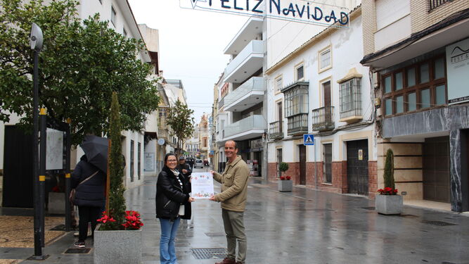 Valeriano Rosales, con el cartel del concurso, en una calle comercial de Montilla.
