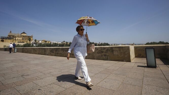 Una mujer se protege con un paraguas del intenso calor en Córdoba.