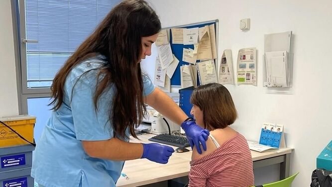 Una enfermera vacuna a una mujer.