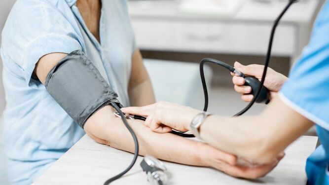 Una enfermera mide la tensión arterial a una paciente.