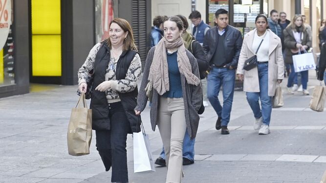 Varias personas pasean por la calle Conde de Gondomar este domingo con bolsas.