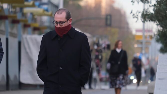 Una persona con bufanda por el frío camina en Córdoba.