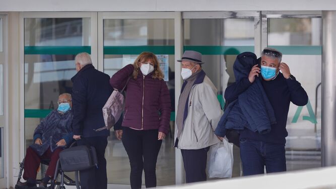 Varias personas, con mascarilla, a las puertas de un centro sanitario.
