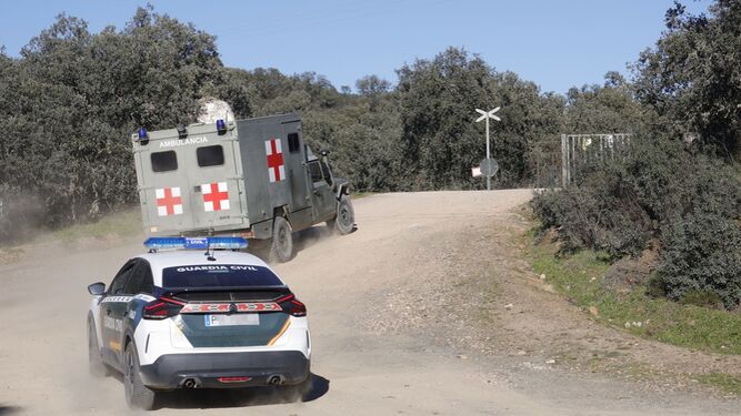 Una ambulancia militar y un coche de la Guardia Civil, entrando en la base de Cerro Muriano.
