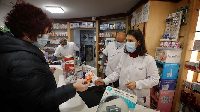 Una empleada de farmacia atiende a una clienta en Huelva.