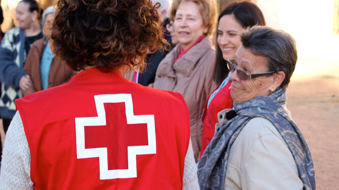Voluntarias de Cruz Roja, junto a un grupo de personas mayores.