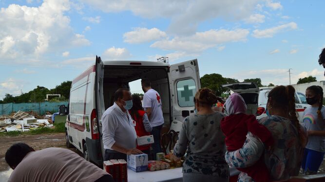 Los voluntarios de Cruz Roja reparten comida en un asentamiento.