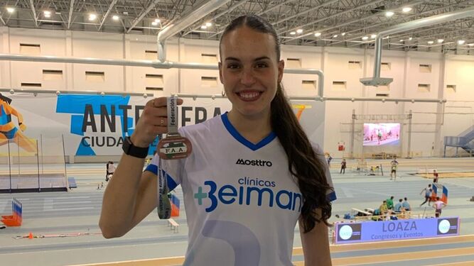 Carmen Avilés muestra la medalla conseguida en el Campeonato de Andalucía de atletismo en pista cubierta.