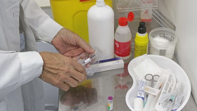Un enfermero sujeta una vacuna en un centro de vacunación internacional.