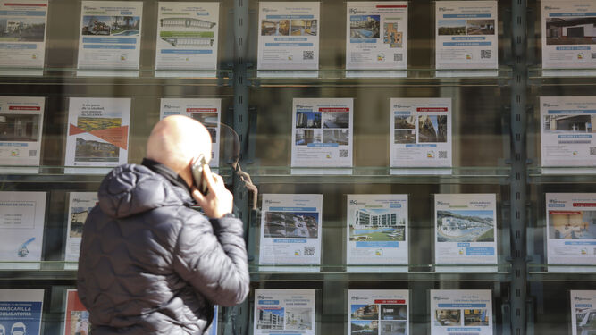 Un hombre mira los carteles de una inmobiliaria.