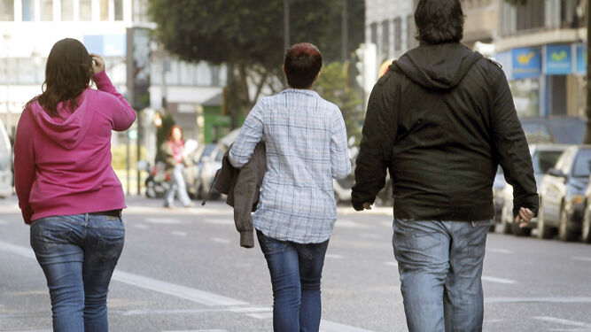 Tres jóvenes pasean por una calle de la capital valenciana.