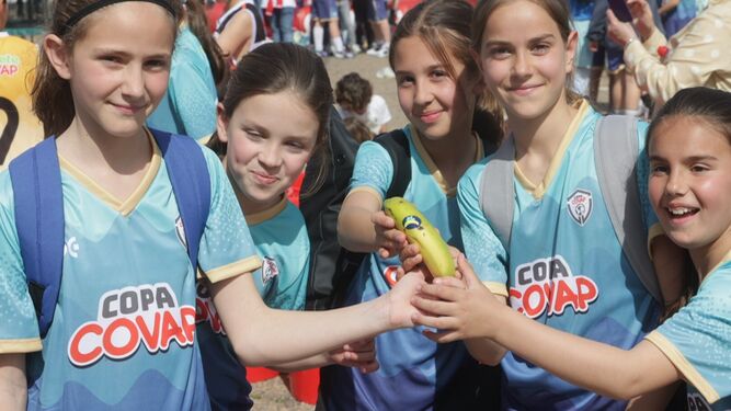 Un grupo de chicas participantes en la Copa COVAP muestran un plátano como ejemplo de merienda saludable.