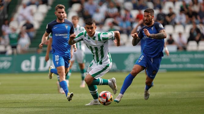Kuki Zalazar persigue el balón entre dos rivales en un momento del Córdoba CF - San Fernando.