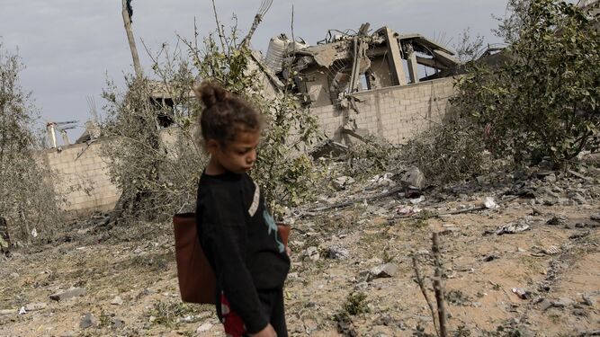 Una niña desplazada del norte de la Franja camina junto a su casa destruida en el campo de refugiados de Rafah.